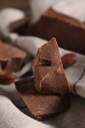 Photo of Pieces of tasty milk chocolate on table, closeup