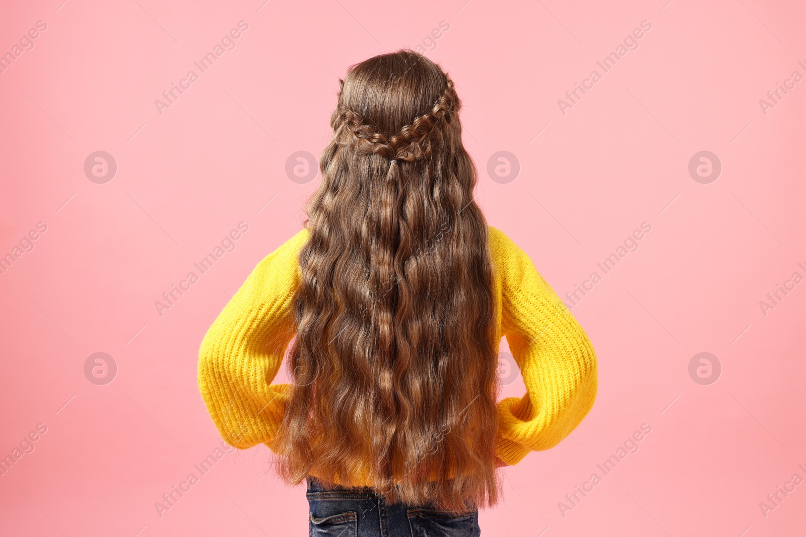 Photo of Little girl with braided hair on pink background, back view