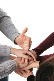 Photo of Young people putting their hands together on white background, closeup