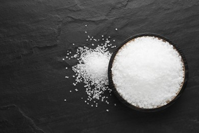 Natural sea salt on black table, flat lay, Space for text