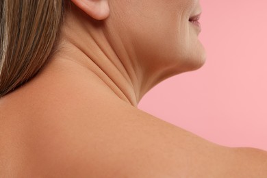 Photo of Mature woman with healthy skin on pink background, closeup