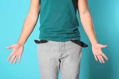 Photo of Man showing empty pockets on color background, closeup