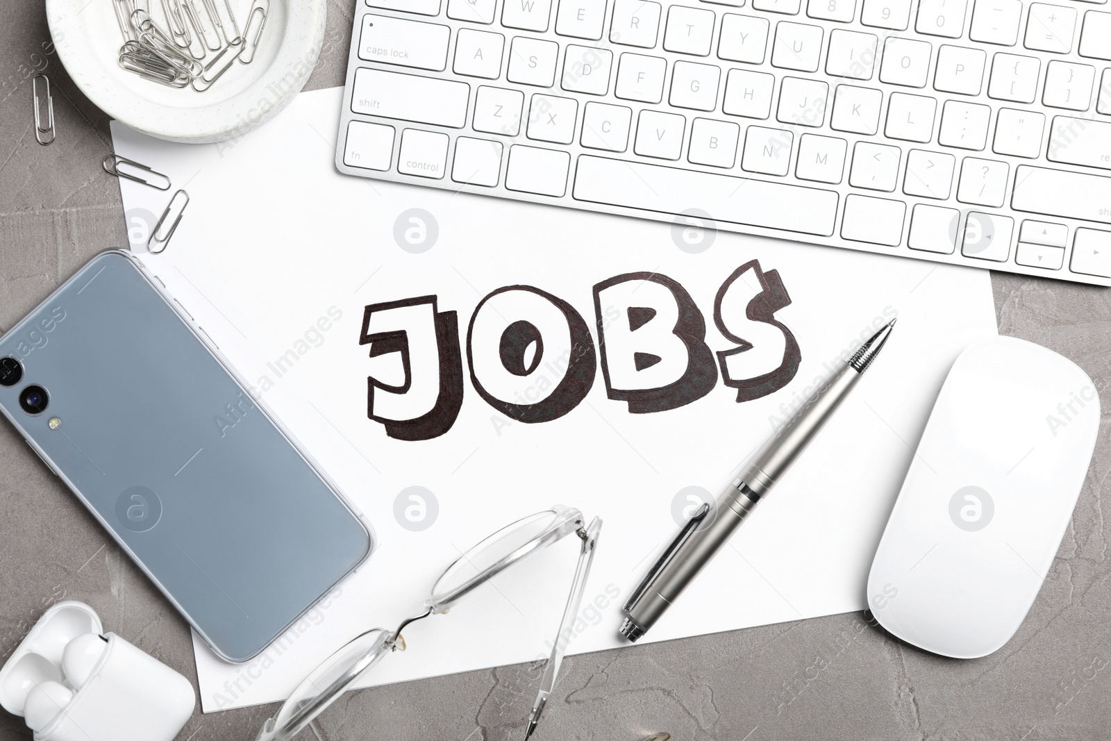 Photo of Flat lay composition with word JOBS, computer keyboard, smartphone and stationery on grey table. Career concept