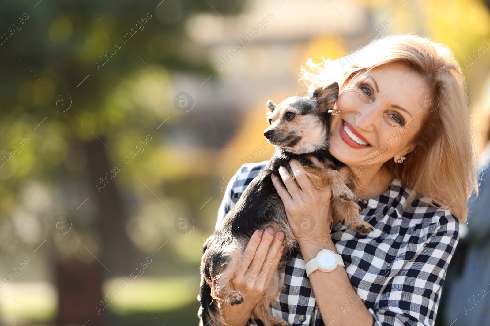 Photo of Beautiful mature woman with cute dog in park