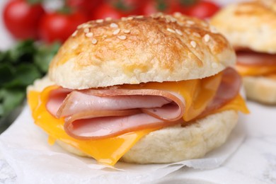 Photo of Delicious bagel with ham and cheese on table, closeup