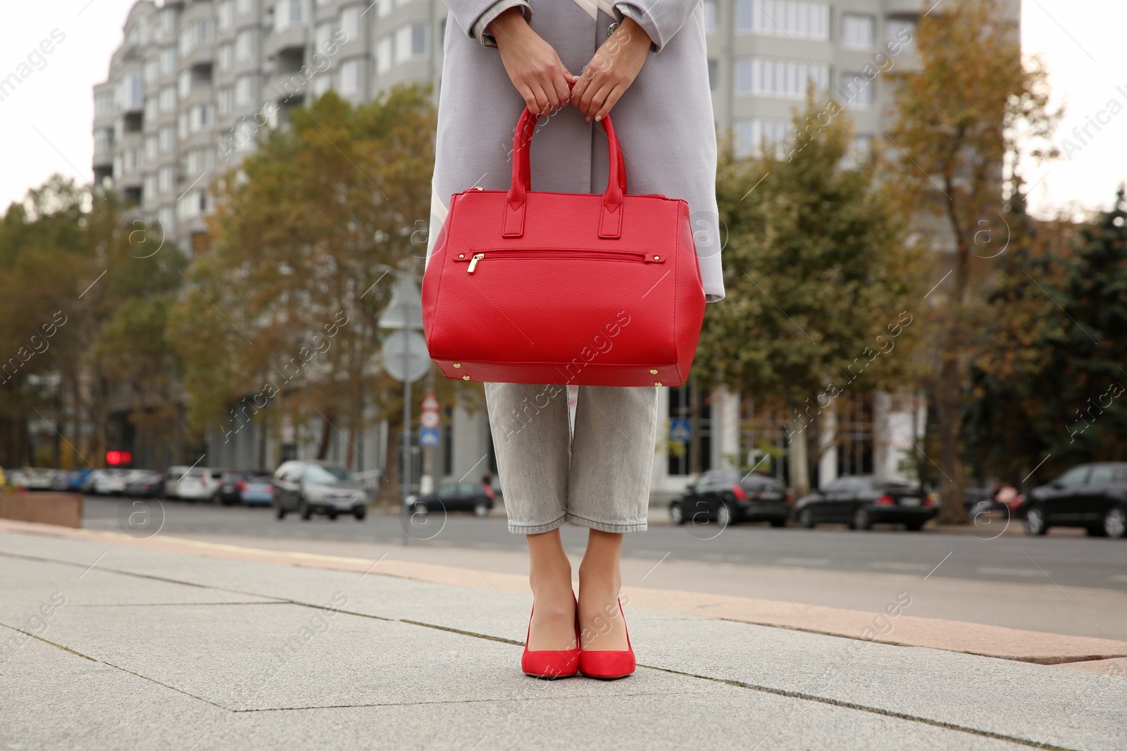 Photo of Stylish woman with trendy leather bag on city street, closeup