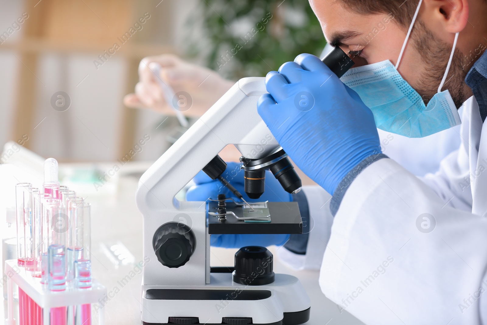 Photo of Male scientist working with microscope in laboratory. Research and analysis