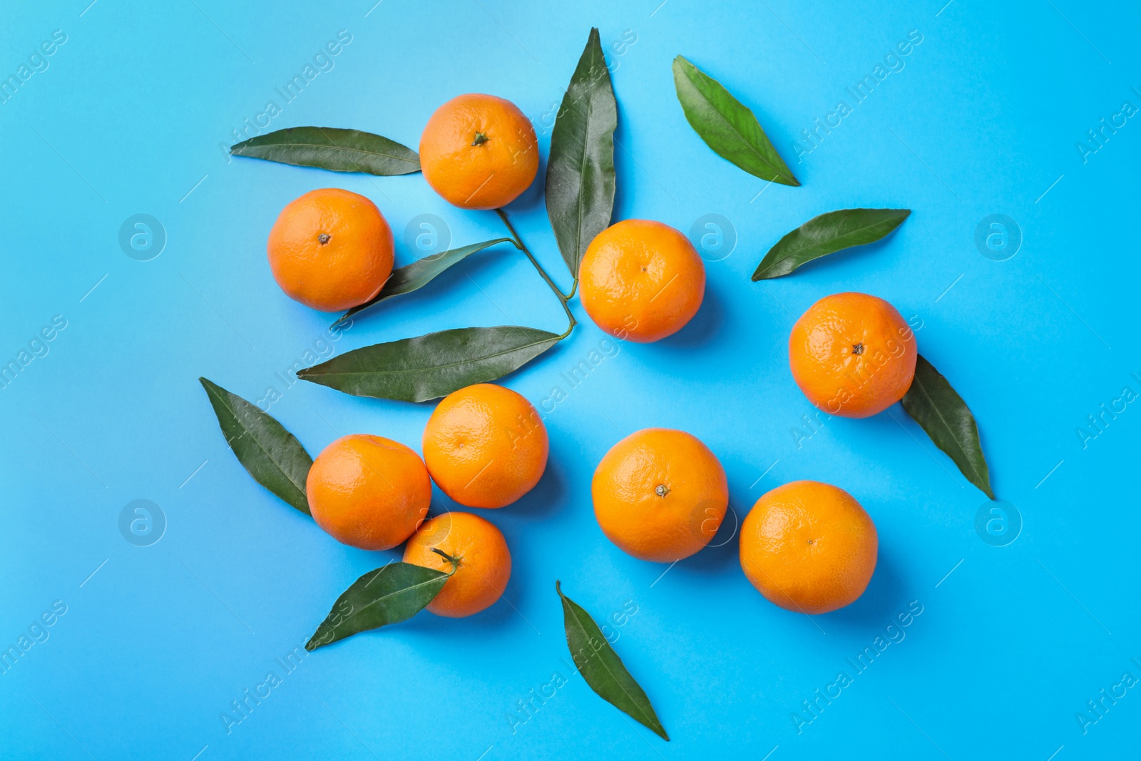 Photo of Fresh ripe tangerines on light blue background, flat lay