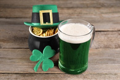 St. Patrick's day celebration. Green beer, leprechaun hat, pot of gold and decorative clover leaf on wooden table