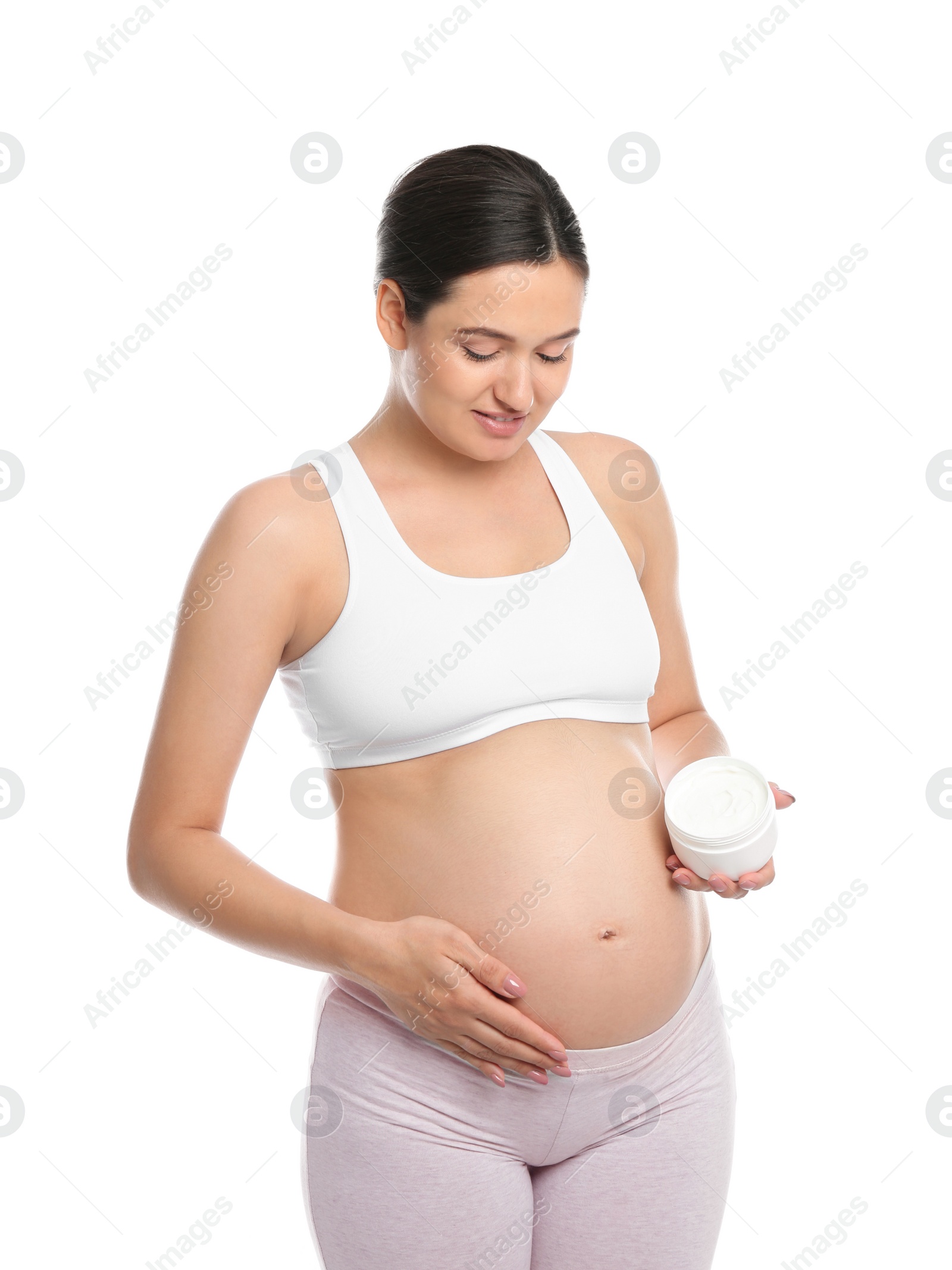 Photo of Pregnant woman holding body cream on white background