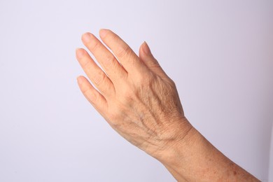 Photo of Closeup view of older woman's hand on white background