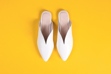 Pair of female shoes on color background, top view