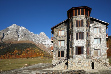 Exterior of stone building in high mountains under blue sky on sunny day