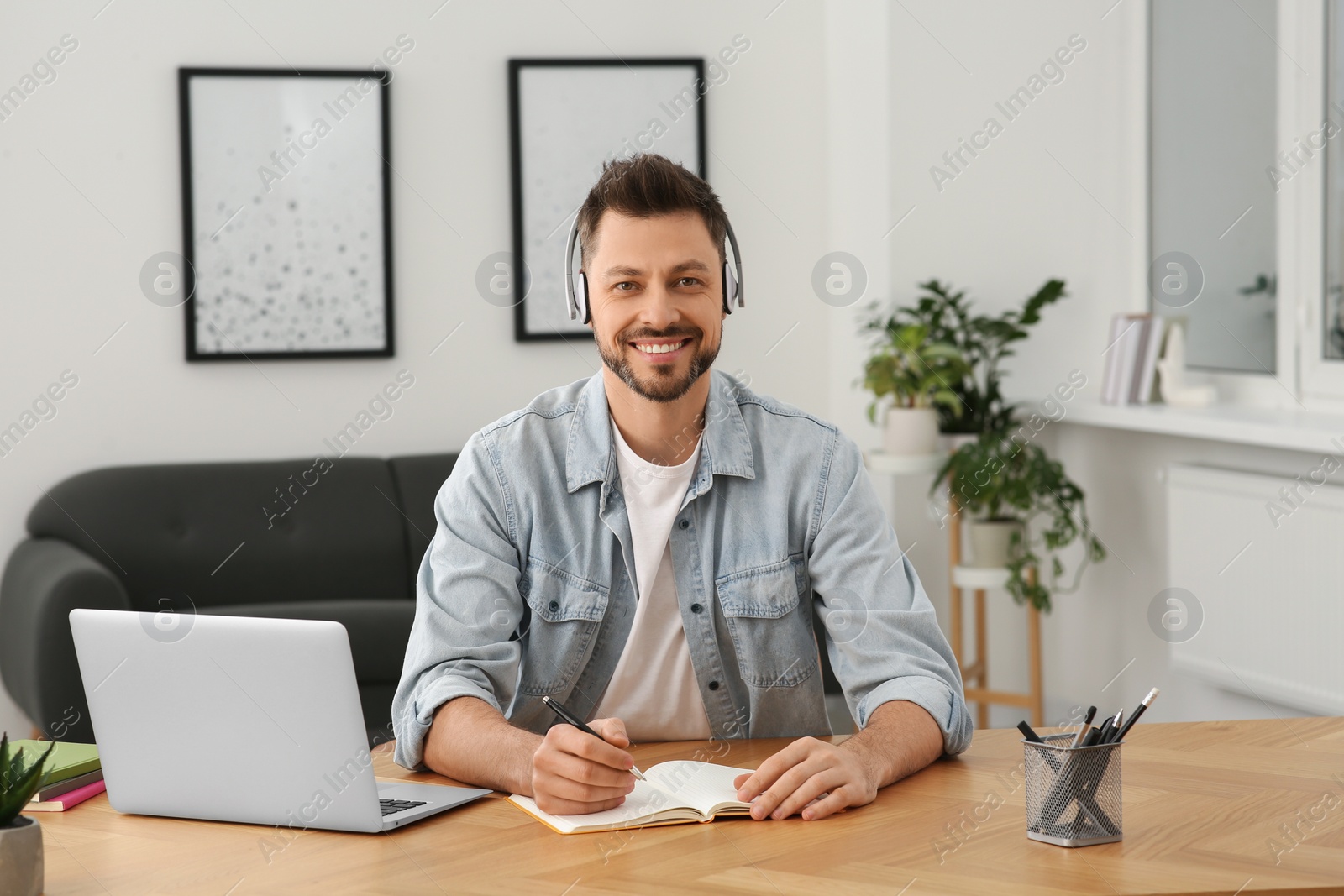 Photo of Man in headphones studying at home. Online translation course