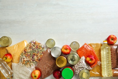 Photo of Many different products and space for text on white wooden background, flat lay. Food donation