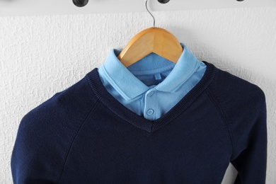 Shirt and jumper on hanger indoors. School uniform