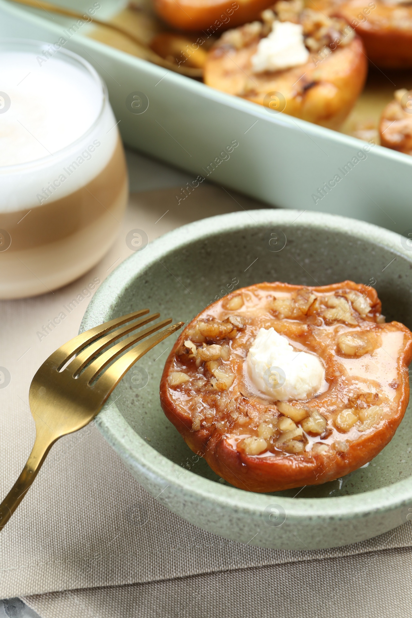 Photo of Tasty baked quince with nuts and cream cheese in bowl on table