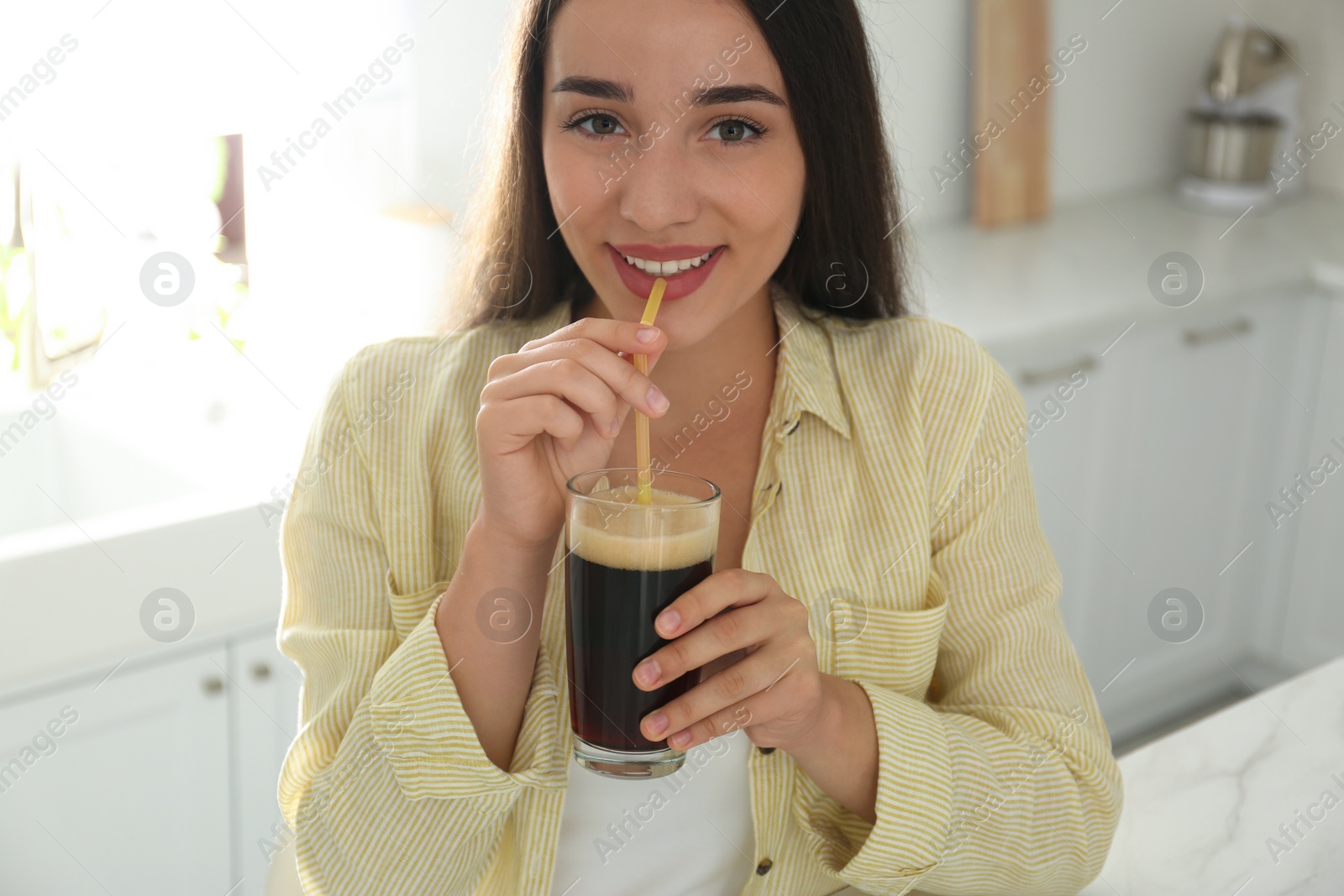 Photo of Beautiful woman with cold kvass indoors. Traditional Russian summer drink