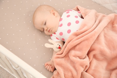 Cute baby girl sleeping in crib. Bedtime schedule