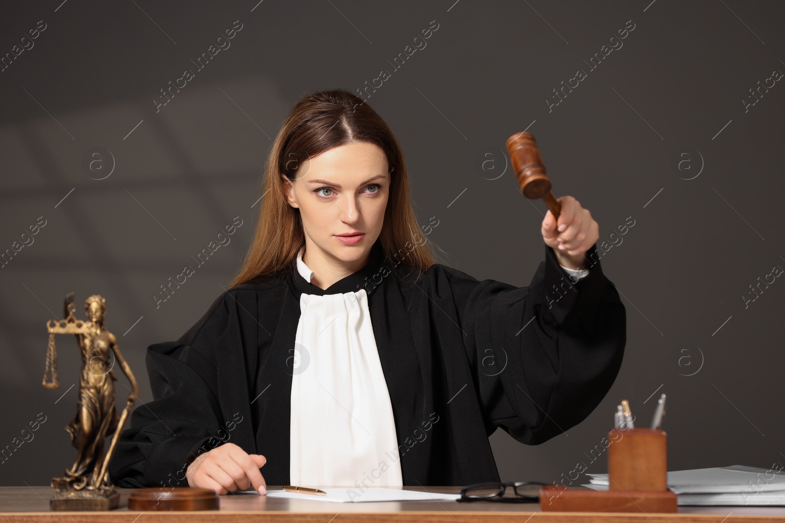 Photo of Judge striking mallet at wooden table indoors