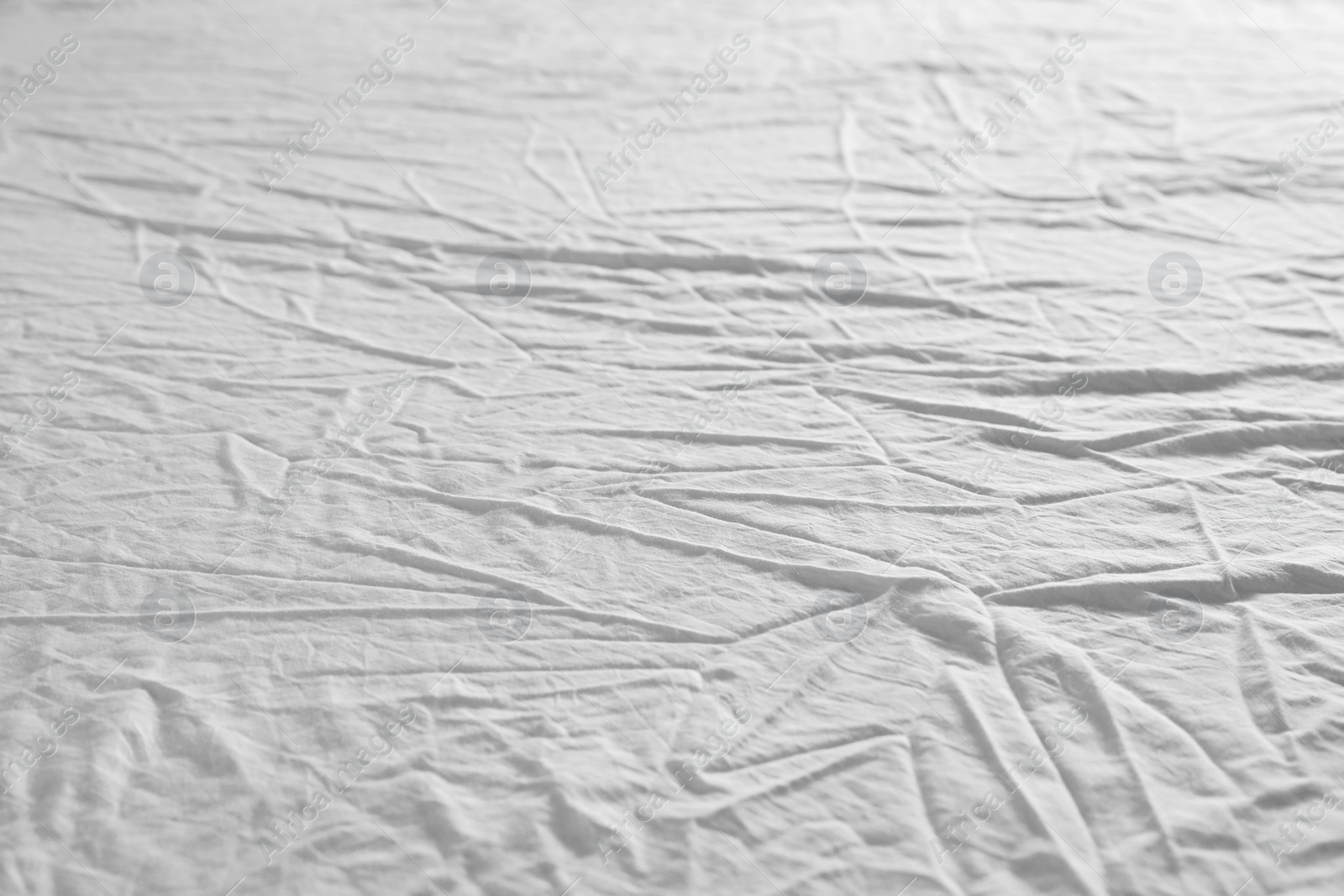 Photo of Crumpled white fabric as background, closeup view