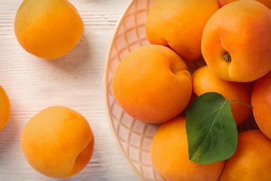 Composition with delicious ripe apricots on white wooden background, top view