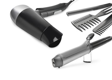 Image of Hair dryer, curling iron and combs on white background