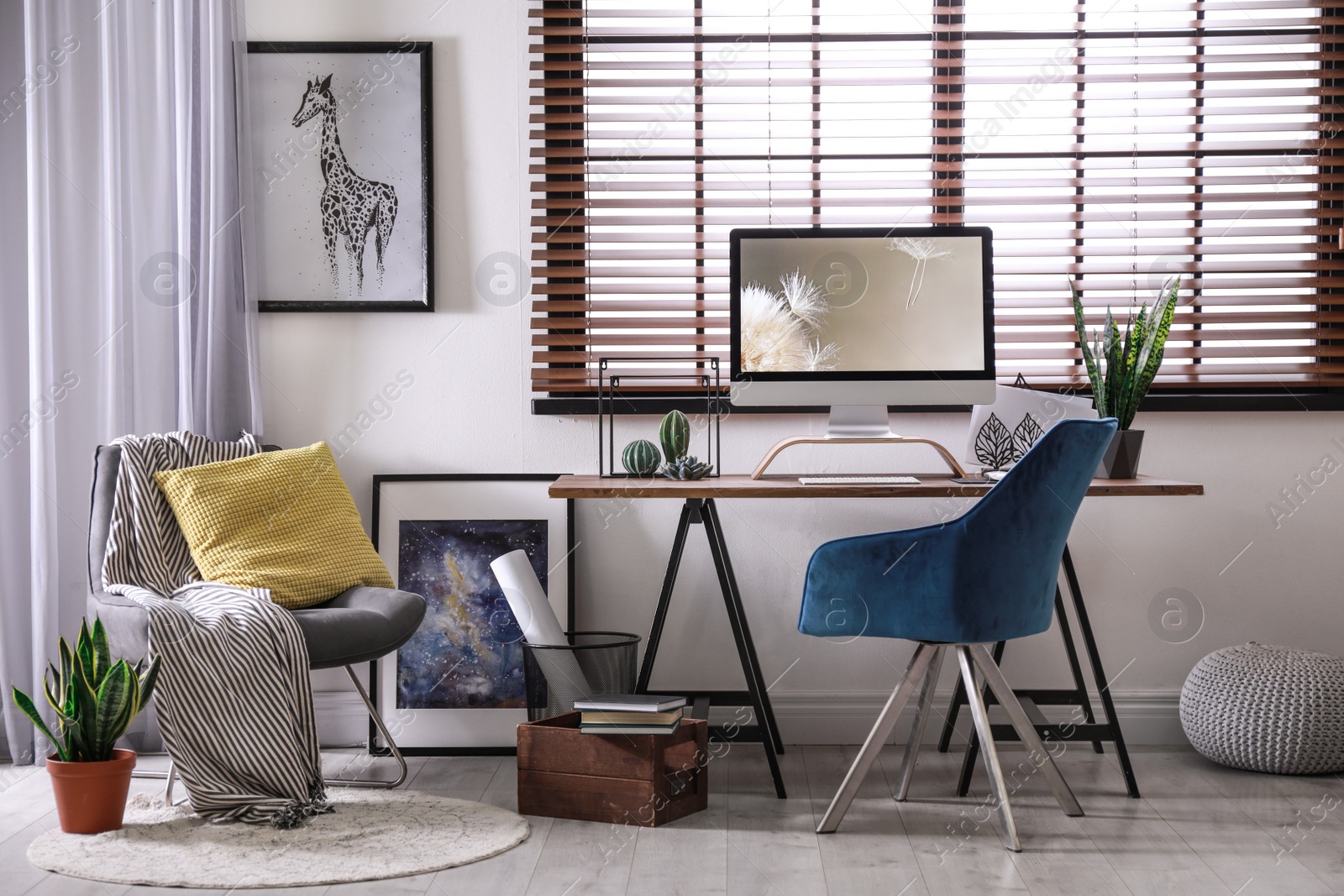 Photo of Comfortable workplace near window with horizontal blinds in room