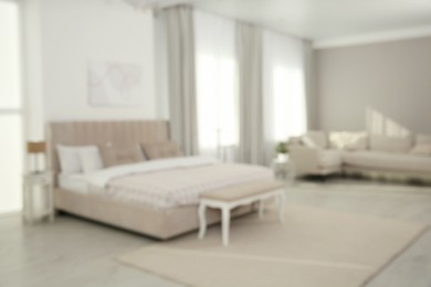 Photo of Blurred view of stylish hotel bedroom interior with modern furniture