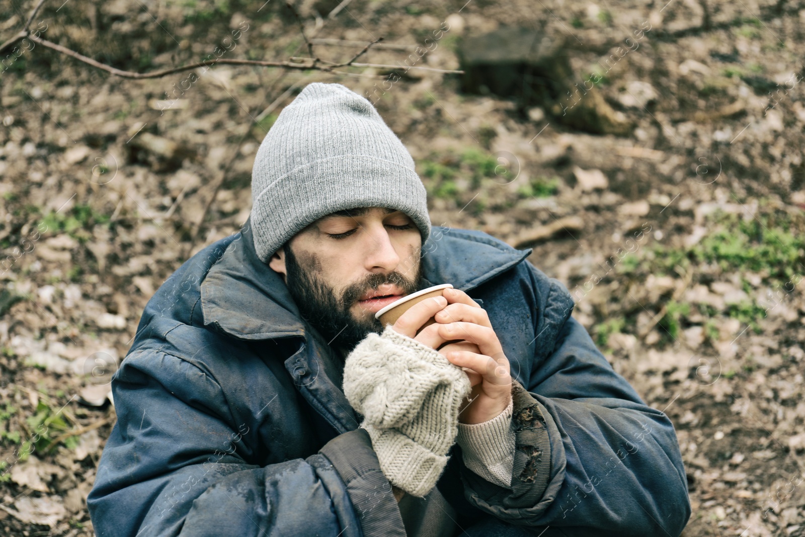 Photo of Poor homeless man with cup in city park