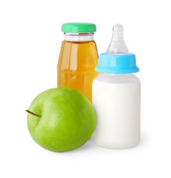 Photo of Bottles with milk, juice and apple on light grey background. Baby nutrition