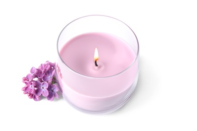 Pink wax candle in glass holder and lilac flowers isolated on white