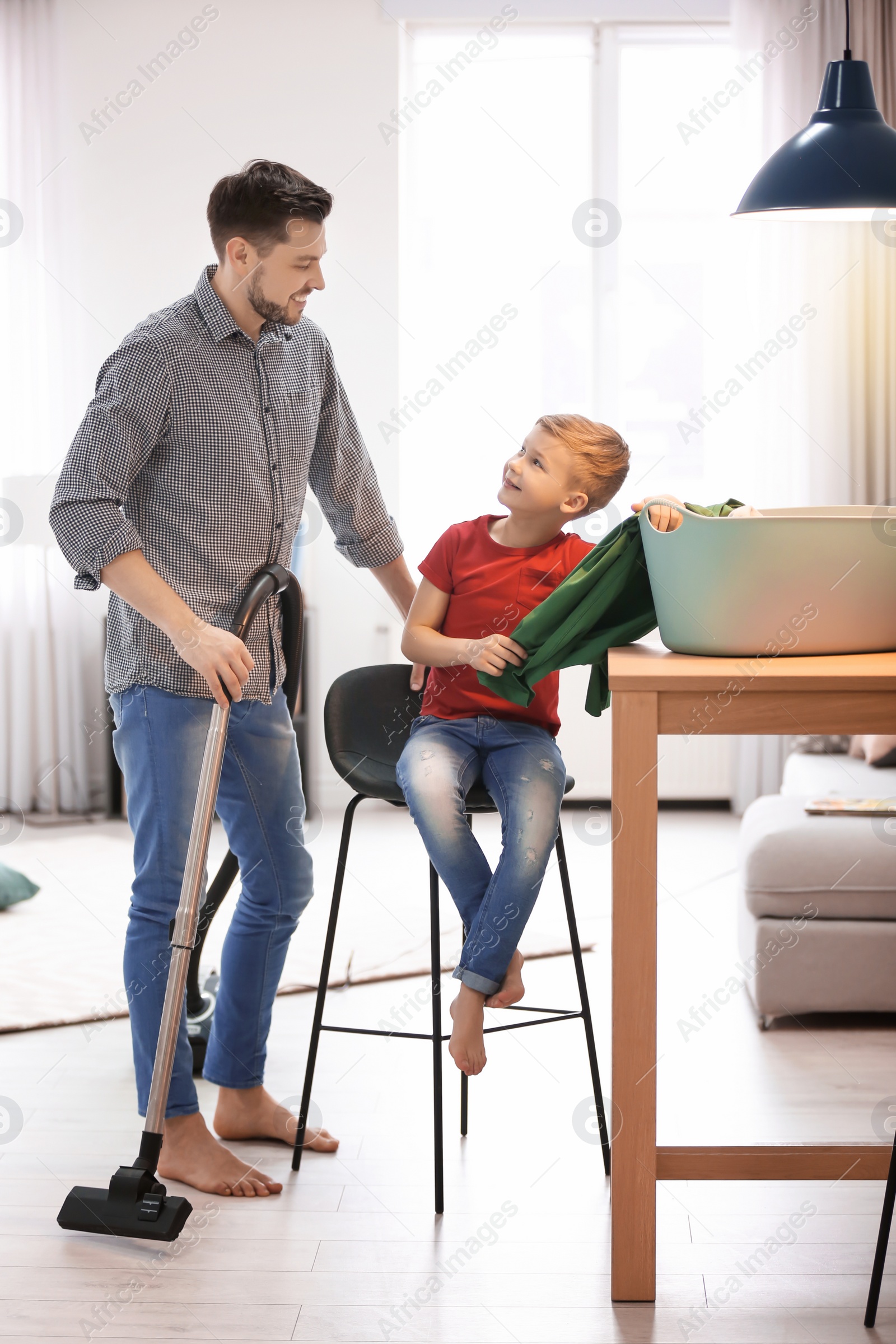 Photo of Little boy and his dad cleaning their house together