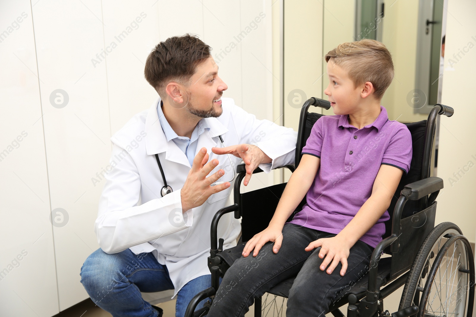 Photo of Doctor and little child in wheelchair at hospital