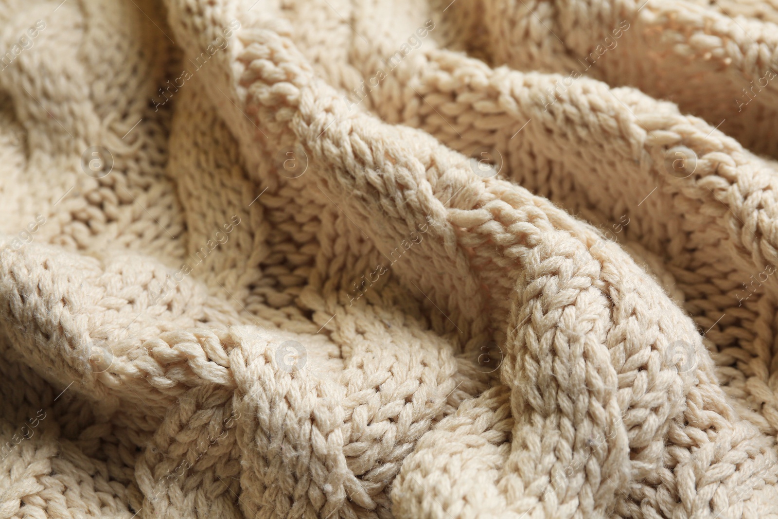 Photo of Beige knitted fabric with beautiful pattern as background, closeup