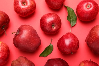Photo of Ripe red apples and green leaves on color background, flat lay