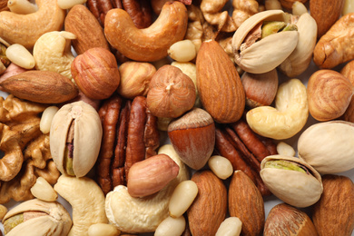 Different delicious nuts as background, closeup view