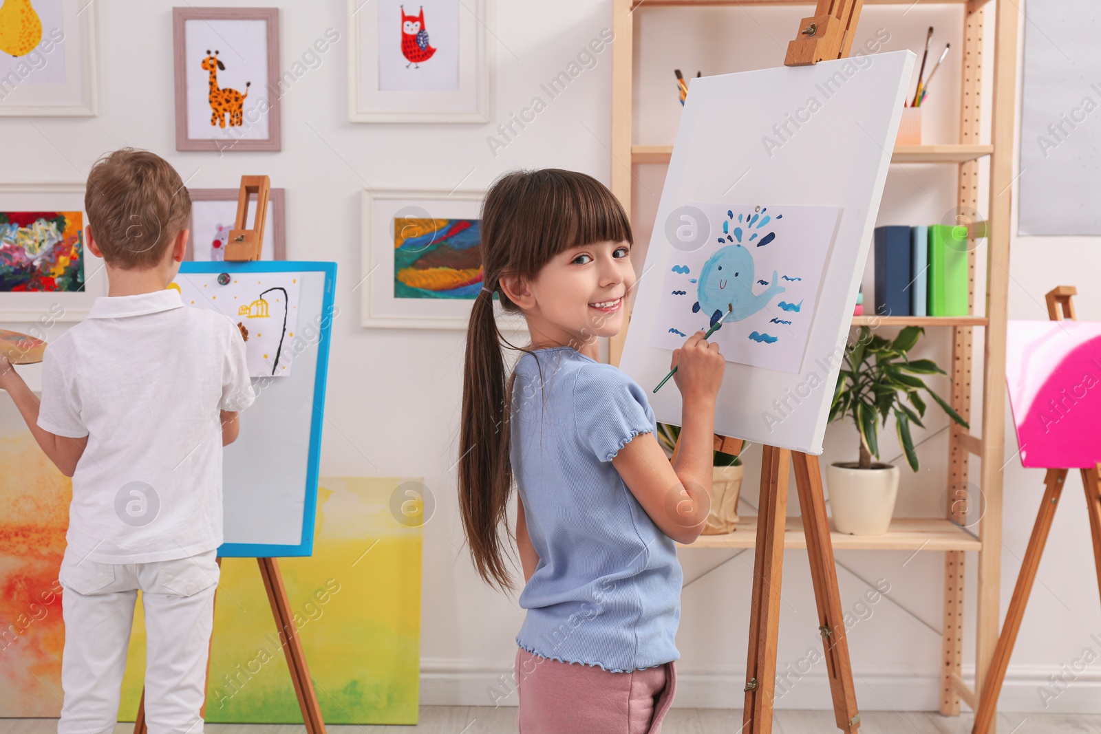 Photo of Cute little children painting during lesson in room