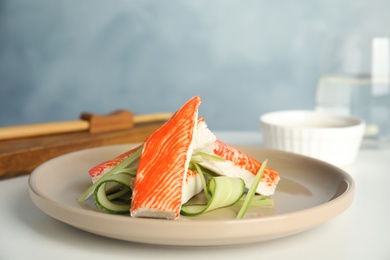 Photo of Fresh crab sticks with cucumber served on white table
