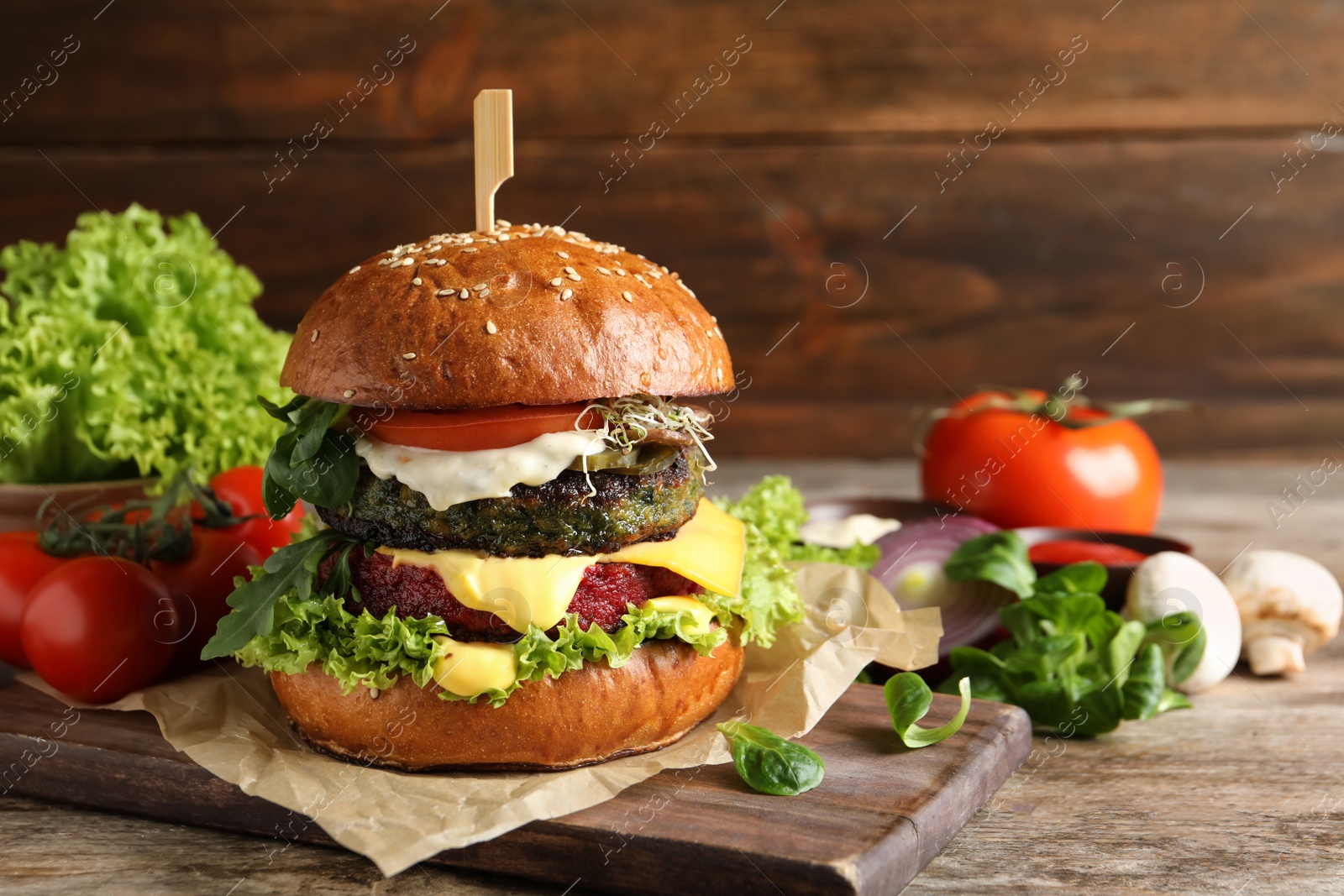 Photo of Vegan burger and vegetables on table against wooden background