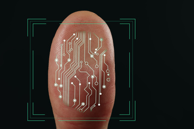 Image of Man using biometric fingerprint scanner on dark background, closeup