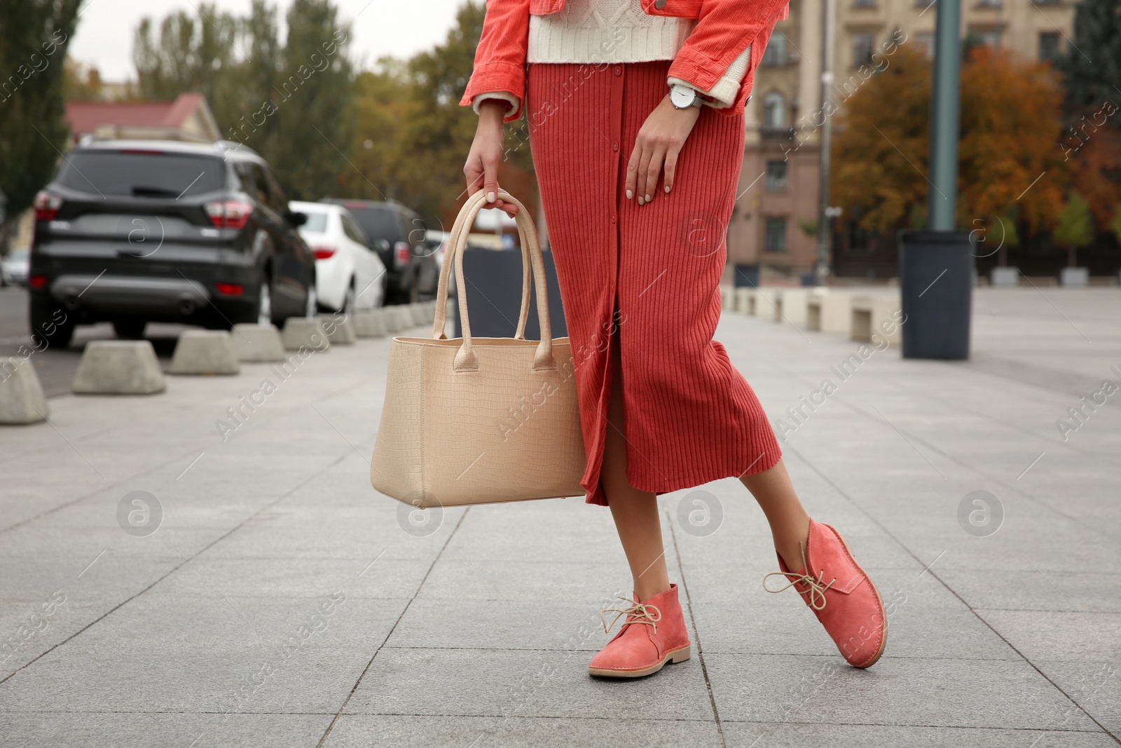 Photo of Stylish woman with trendy leather bag on city street, closeup