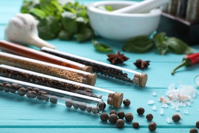 Photo of Composition with various spices and test tubes on light blue wooden table