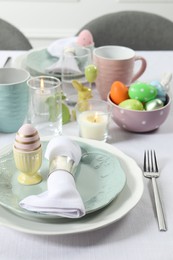 Photo of Easter celebration. Festive table setting with painted eggs.