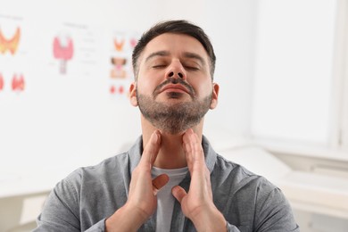 Photo of Endocrine system. Man doing thyroid self examination indoors