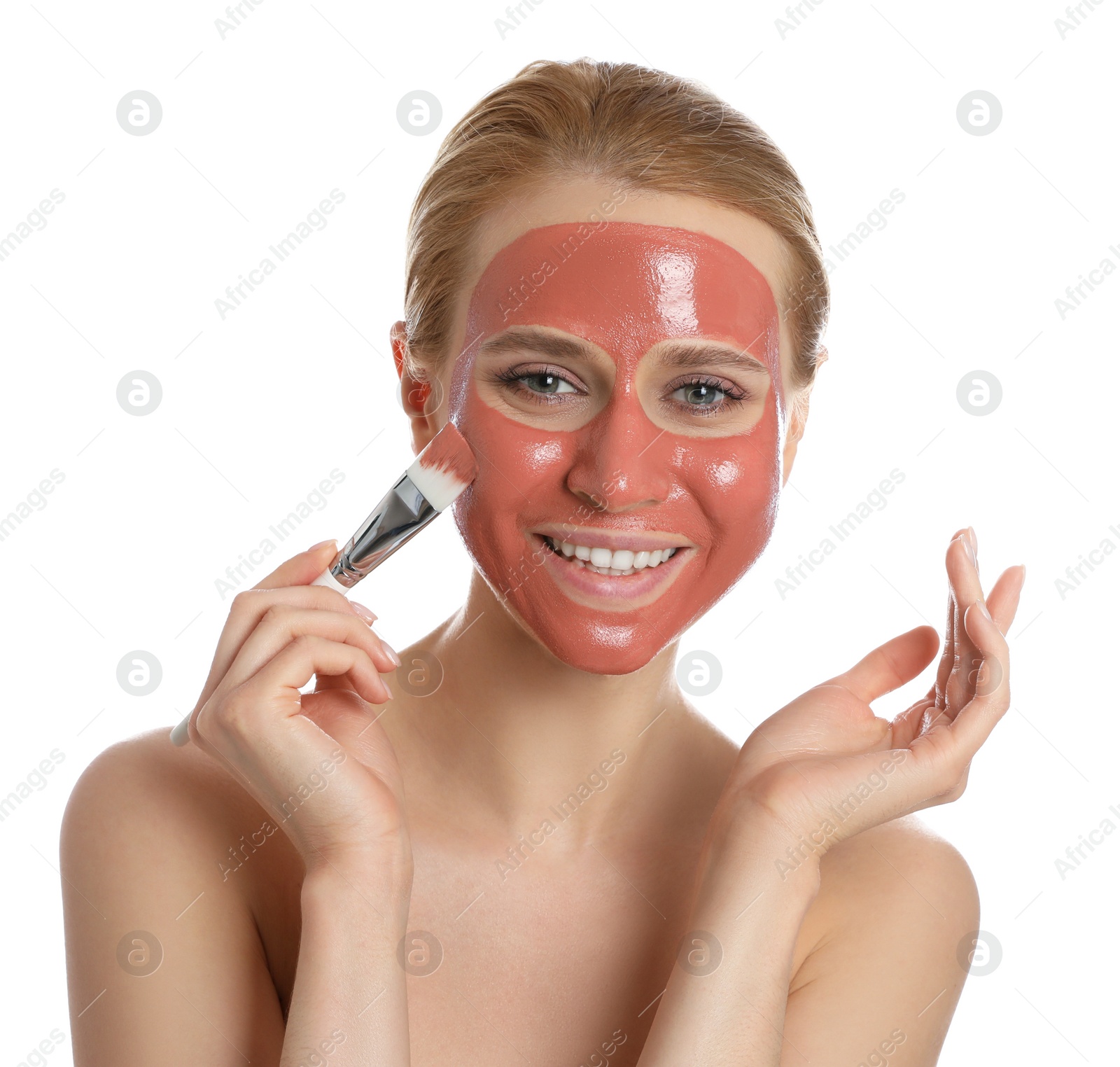 Photo of Young woman applying pomegranate face mask on white background