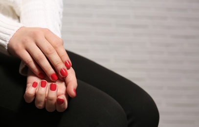 Woman with red manicure on blurred background, space for text. Nail polish trends