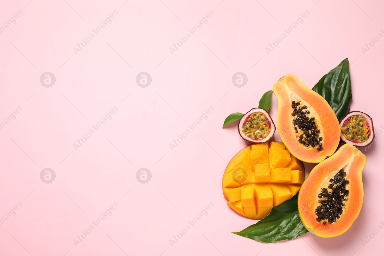 Photo of Fresh ripe papaya and other fruits on pink background, flat lay. Space for text