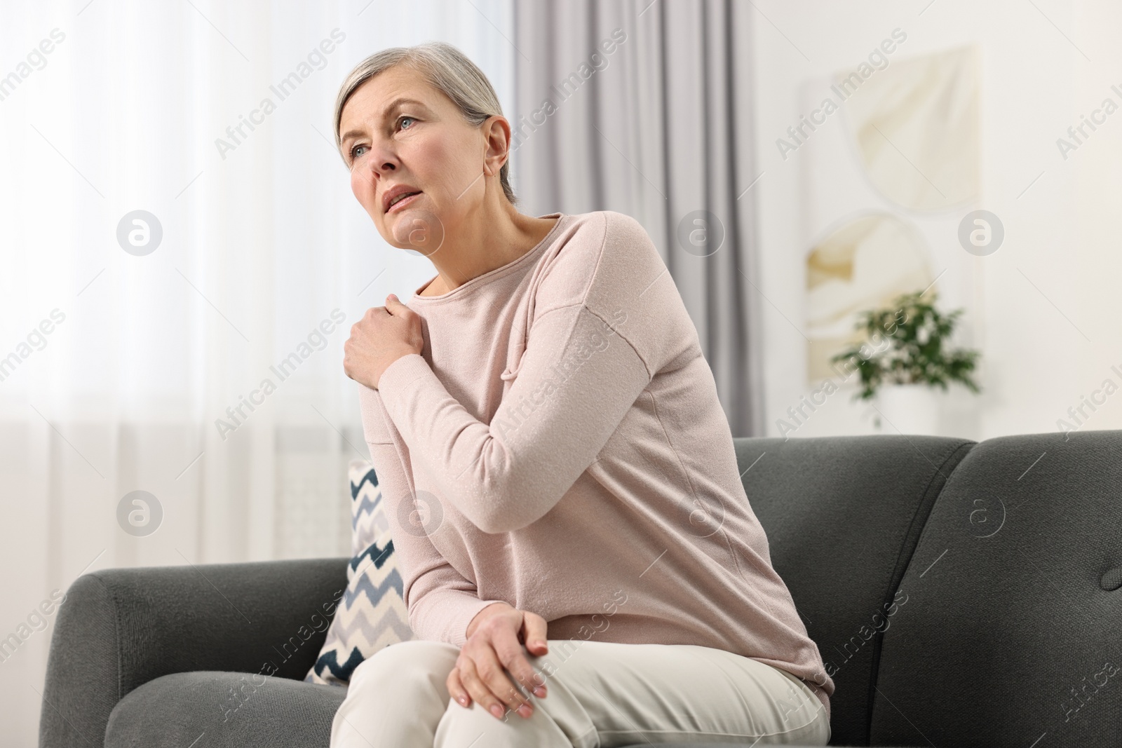 Photo of Arthritis symptoms. Woman suffering from pain in shoulder at home