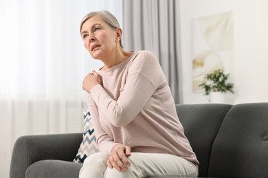 Arthritis symptoms. Woman suffering from pain in shoulder at home